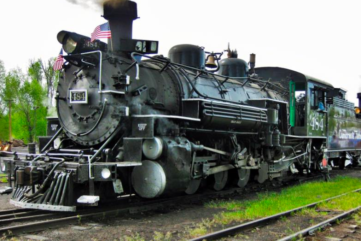 a steam engine is sitting on a train track