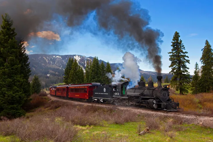 a steam train on a track with smoke coming out of it