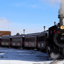a steam engine is sitting on a train track