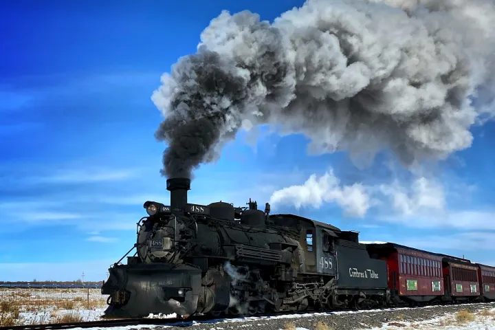 a train on a track with smoke coming out of it