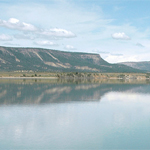 a large body of water with a mountain in the background