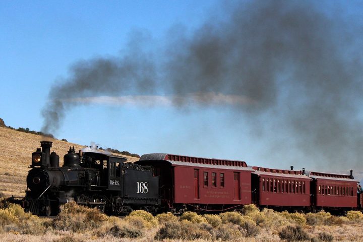 a steam train on a track with smoke coming out of it at the Cumbres and Toltec Scenic Railroad,
