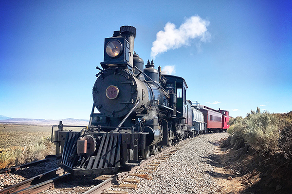 Cumbres & Toltec historic 168 steam locomotive on tracks with clear blue sky in background.