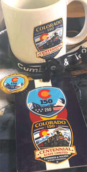 Colorado 150th anniversary memorabilia including mug, button, and badge.