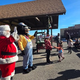 Santa and characters greet people outside a festive venue.