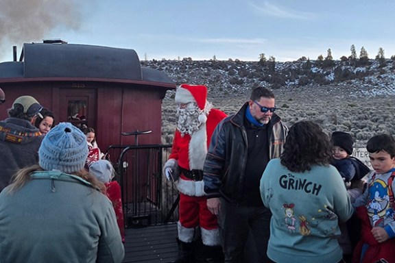 Santa Claus with people on a train platform in winter attire.