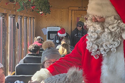Santa Claus interacting with passengers on a festive train ride.